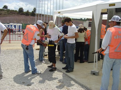 Security guard using handheld metal detector