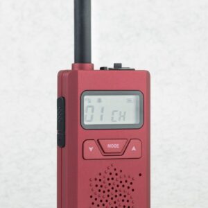 The CPS Telecom CP183 Tiny PMR446 Radio is a red handheld two-way device with a digital "01 CH" display and mode/navigation buttons, standing upright on a light surface.
