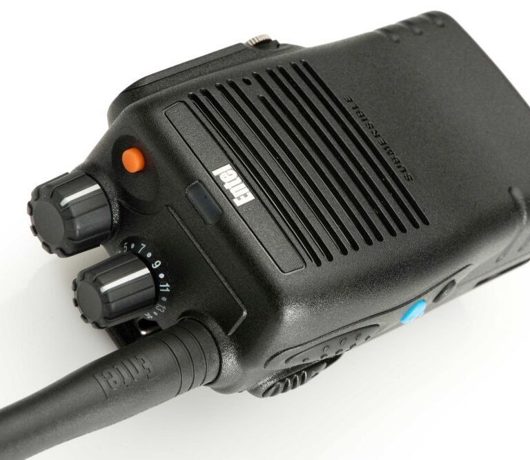 A close-up of the Entel DX482 Digital / Analogue Two-Way Radio, a black handheld device featuring control knobs, buttons, and a visible aerial.