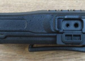 kirisun-dp405-accessory-socket Close-up side view of a Kirisun DP405 Digital / Analogue Walkie-Talkie Radio in black, featuring external accessory ports and a belt clip, resting on a wooden surface.