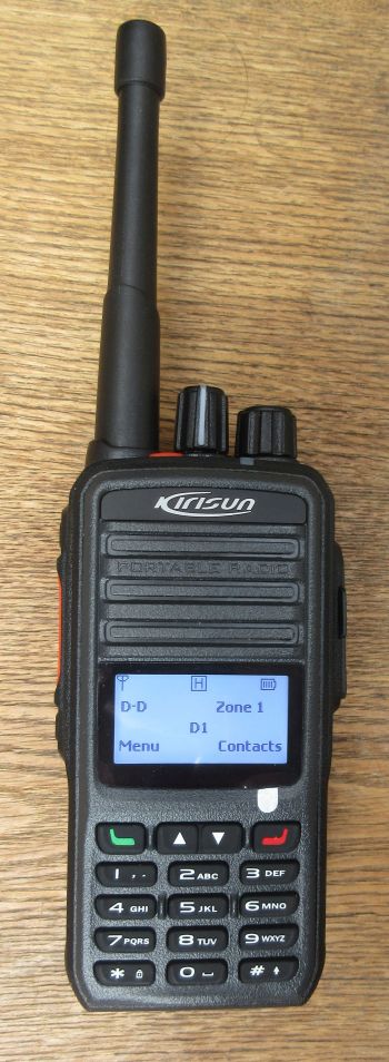kirisun-dp480-walkie-talkie-screen-on A Kirisun DP480 Digital / Analogue Two-Way Radio with a display, keypad, and aerial sits on a wooden surface.