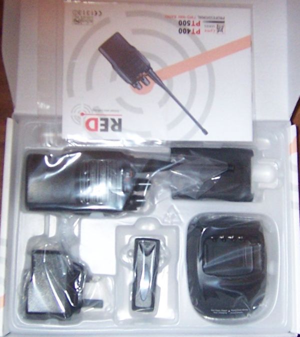 Boxed set includes Lynx PT400 Professional Licence-Free Walkie-Talkie, charging base, power adaptor, belt clip, and instruction manual. Each item is individually packaged in plastic.