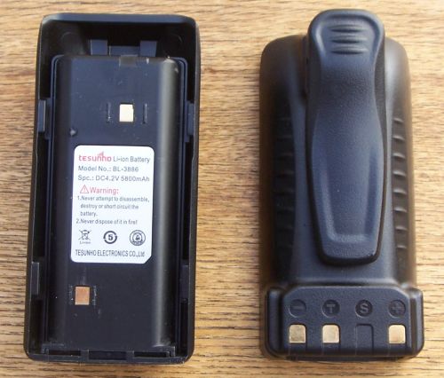 tesunho-th388-battery-bl3886 Two views of the Tesunho TH388 Battery BL3886: the left side displays the label, whilst the right side reveals the back featuring a belt clip and charging contacts.
